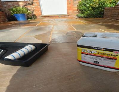 Applying sealer on sandstone paving slabs to prevent water and dirt absorption